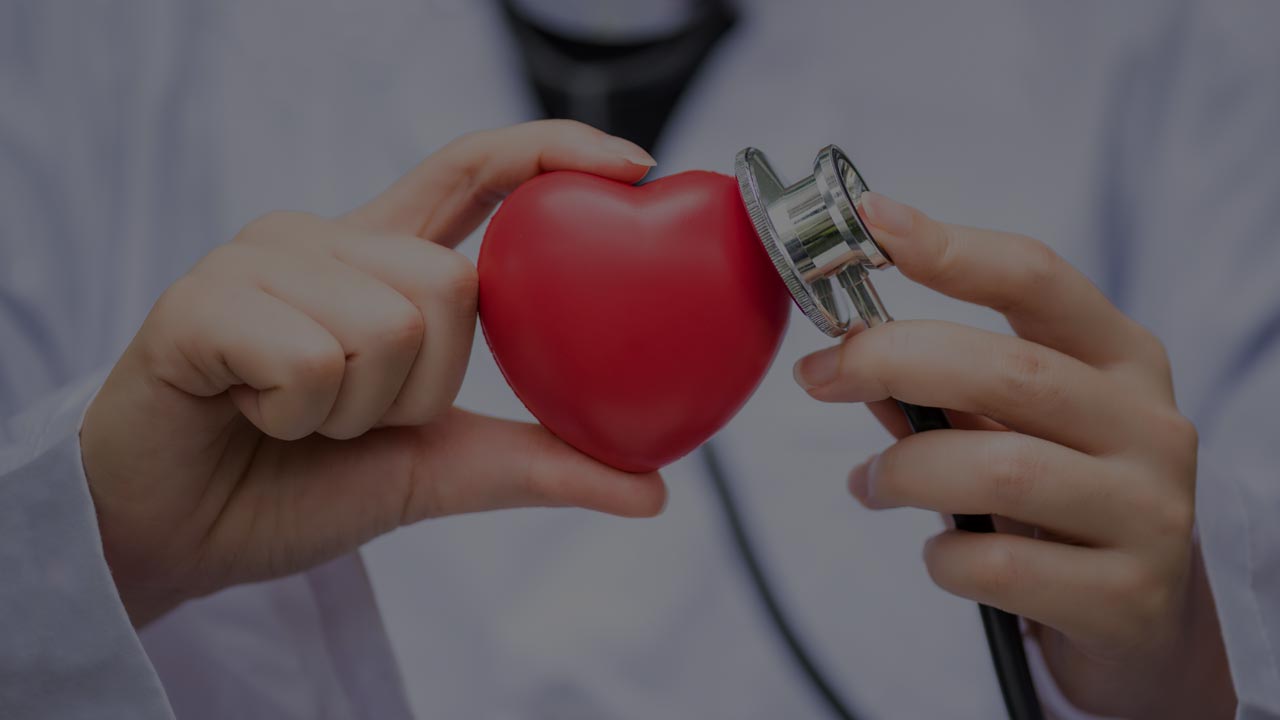 Physician holding a red heart against a stethoscope — Health News Bugle healthcare reporting